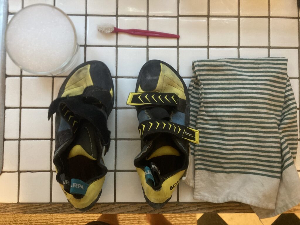 supplies to clean climbing shoes: shoes, soapy water, brush, towel